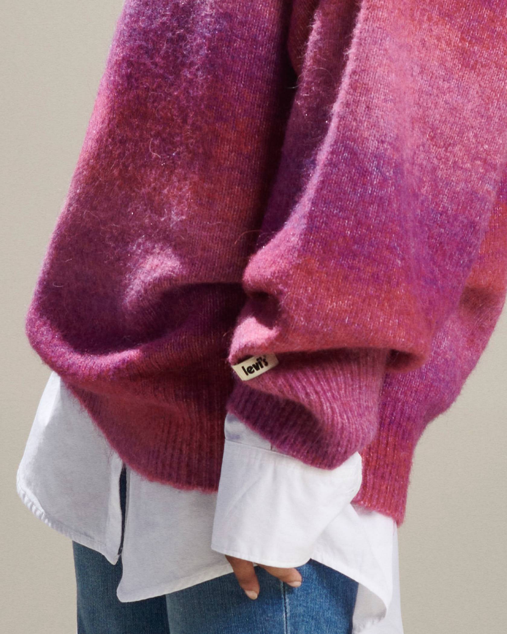 Close up of a fuzzy berry colored sweater on top of a white linen button down and blue jeans 2022_fall_outfits_for_women