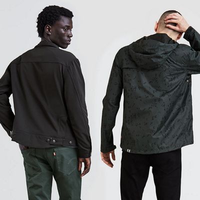 Two men looking backwards and wearing all black.