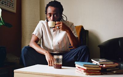 Photo of Joonbug drinking coffee in his home.