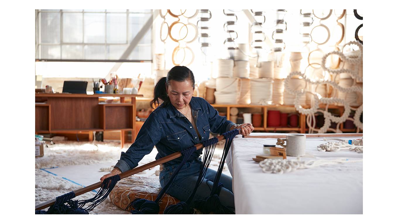 Image of Windy Chien working on a fiber sculpture in her studio.