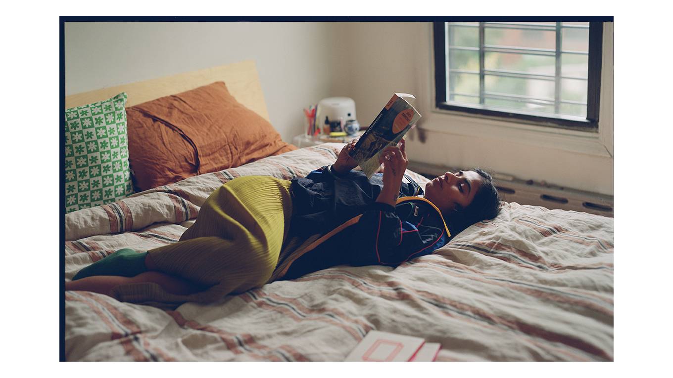 Photo of Fariha Róisín reading on her bed.