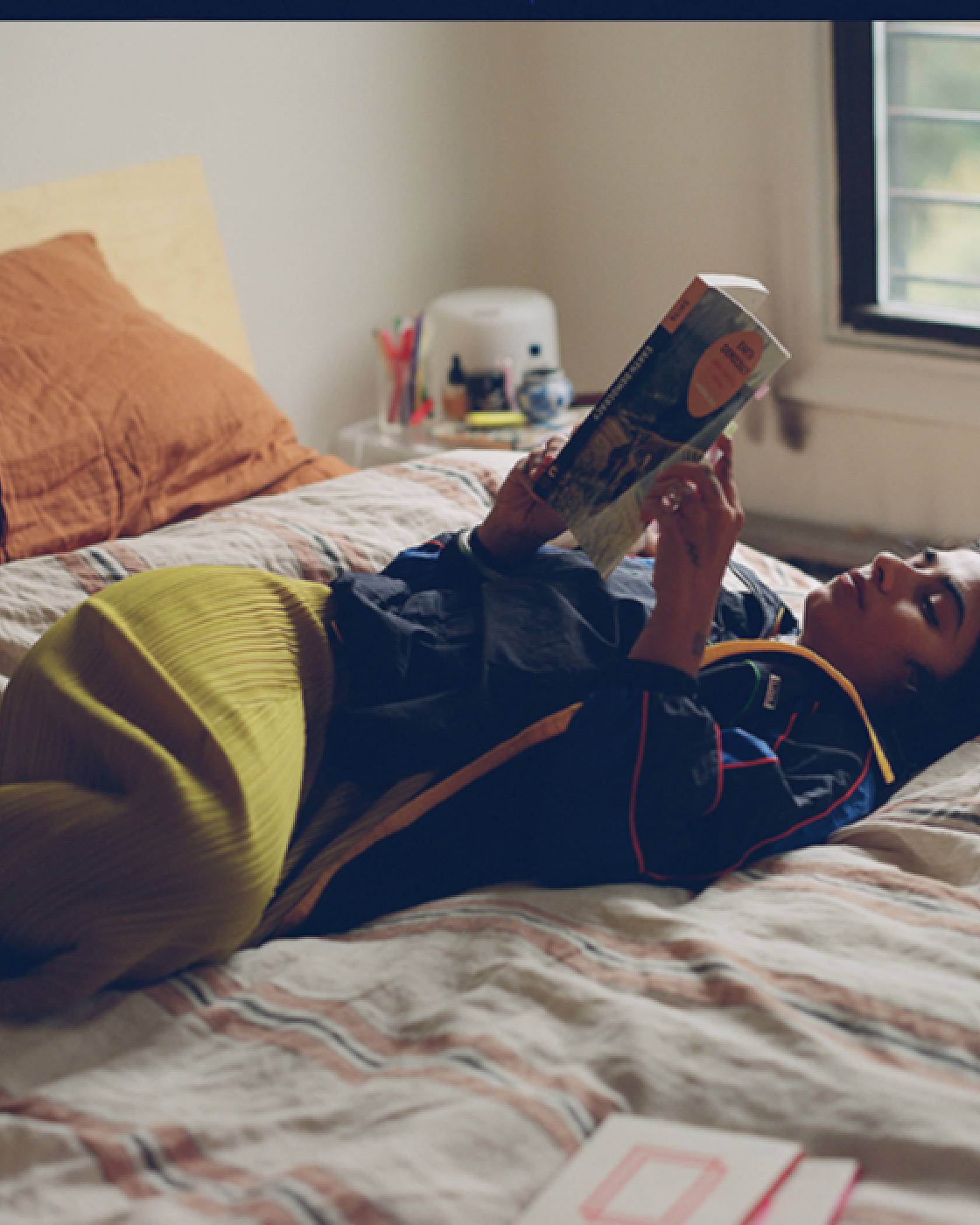 Photo of Fariha Róisín reading on her bed.
