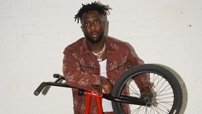 Nigel standing with a red BMX bike.