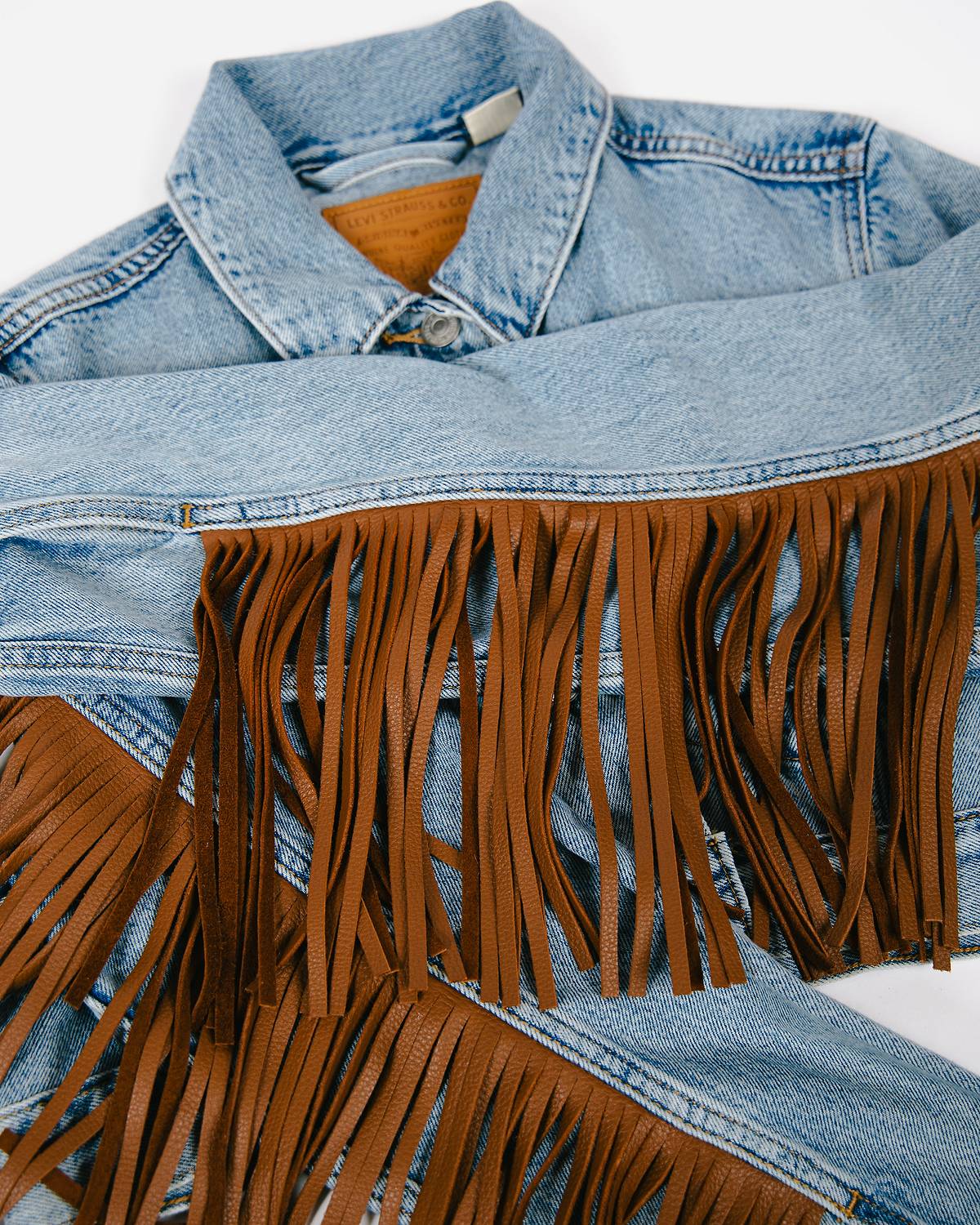 Customized Levi's® Trucker Jacket with brown fringe detailing on the sleeves