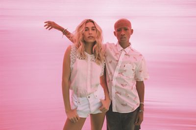Jaden Smith and hailey bieber standing next to each other in front of pink background.