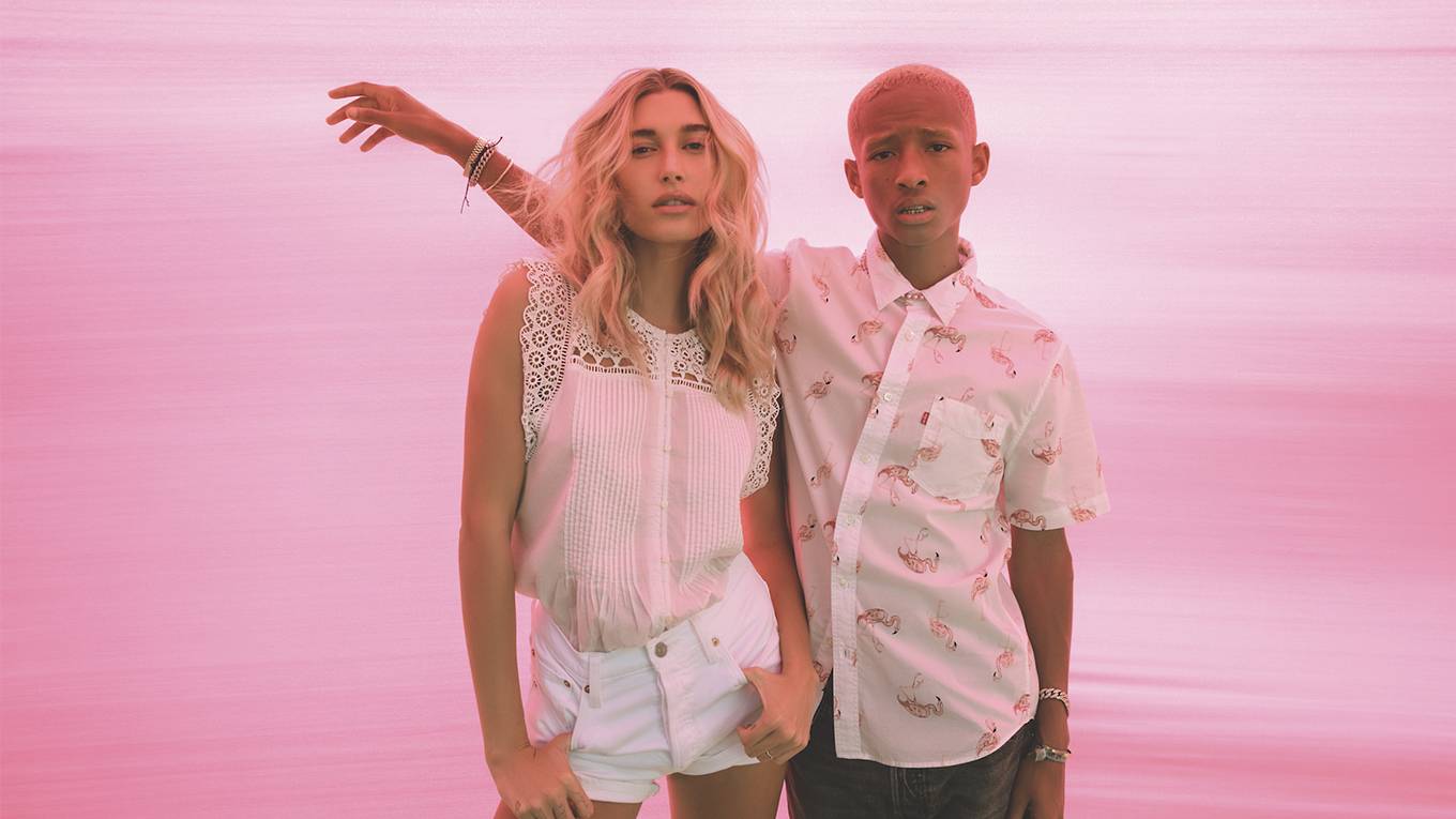 Jaden Smith and hailey bieber standing next to each other in front of pink background.
