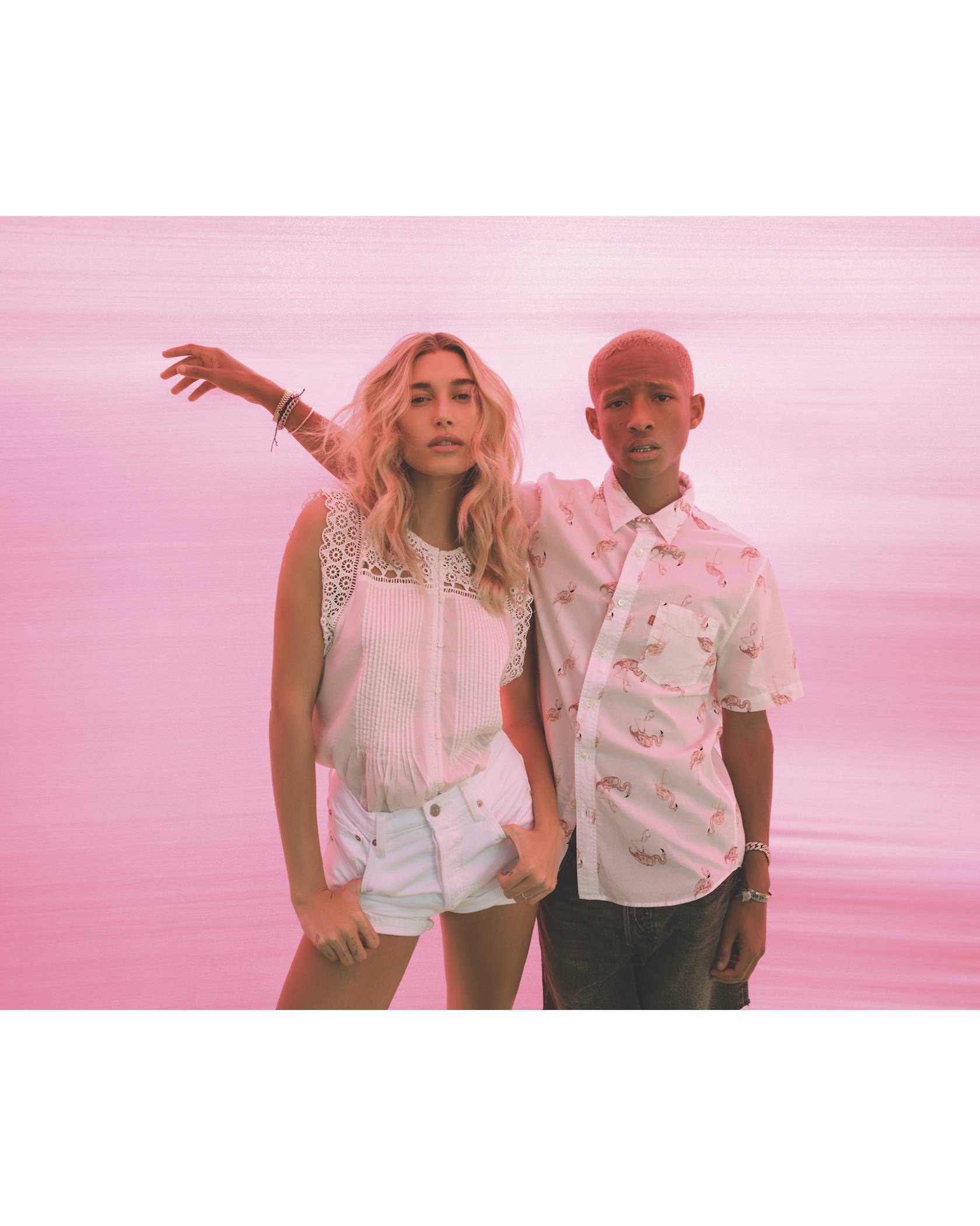 Jaden Smith and hailey bieber standing next to each other in front of pink background.