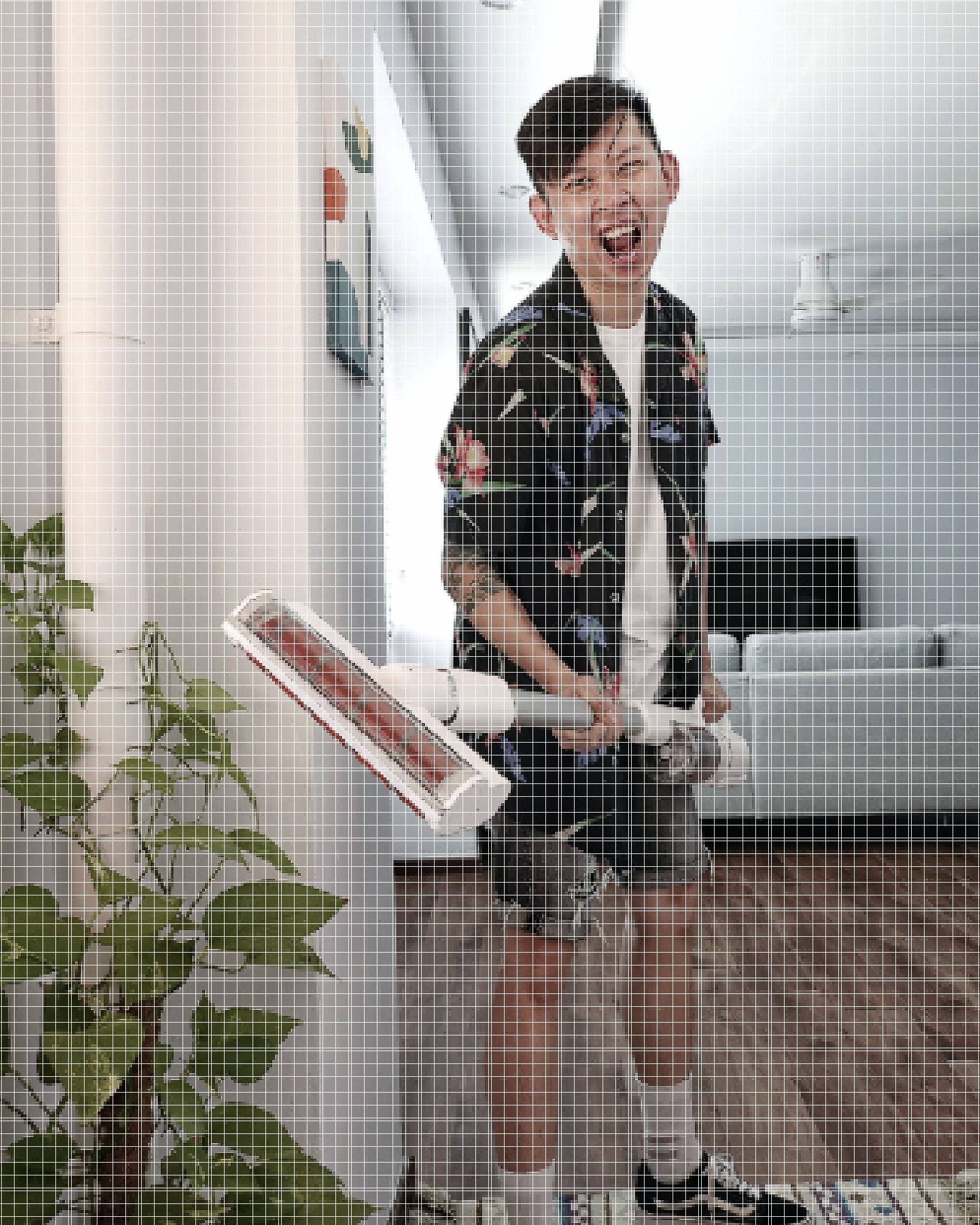 Photo of Mark Chan brandishing a portable vacuum. He is wearing a tropical-print Cubano shirt over a white tee with cut-off denim shorts and white socks with black Vans.