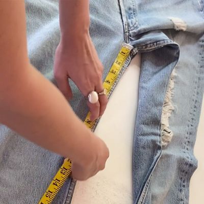 tape measure measuring inseam of blue jeans