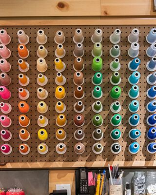 a wall of thread in the tailor shop