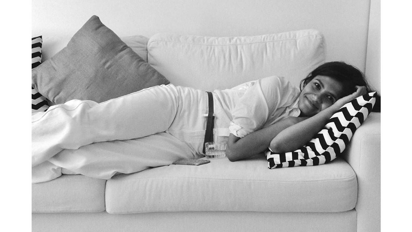 Black and white image of Tasnim Ahmed lying on a couch.