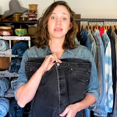 A woman holding jeans showing where the inseam on jeans