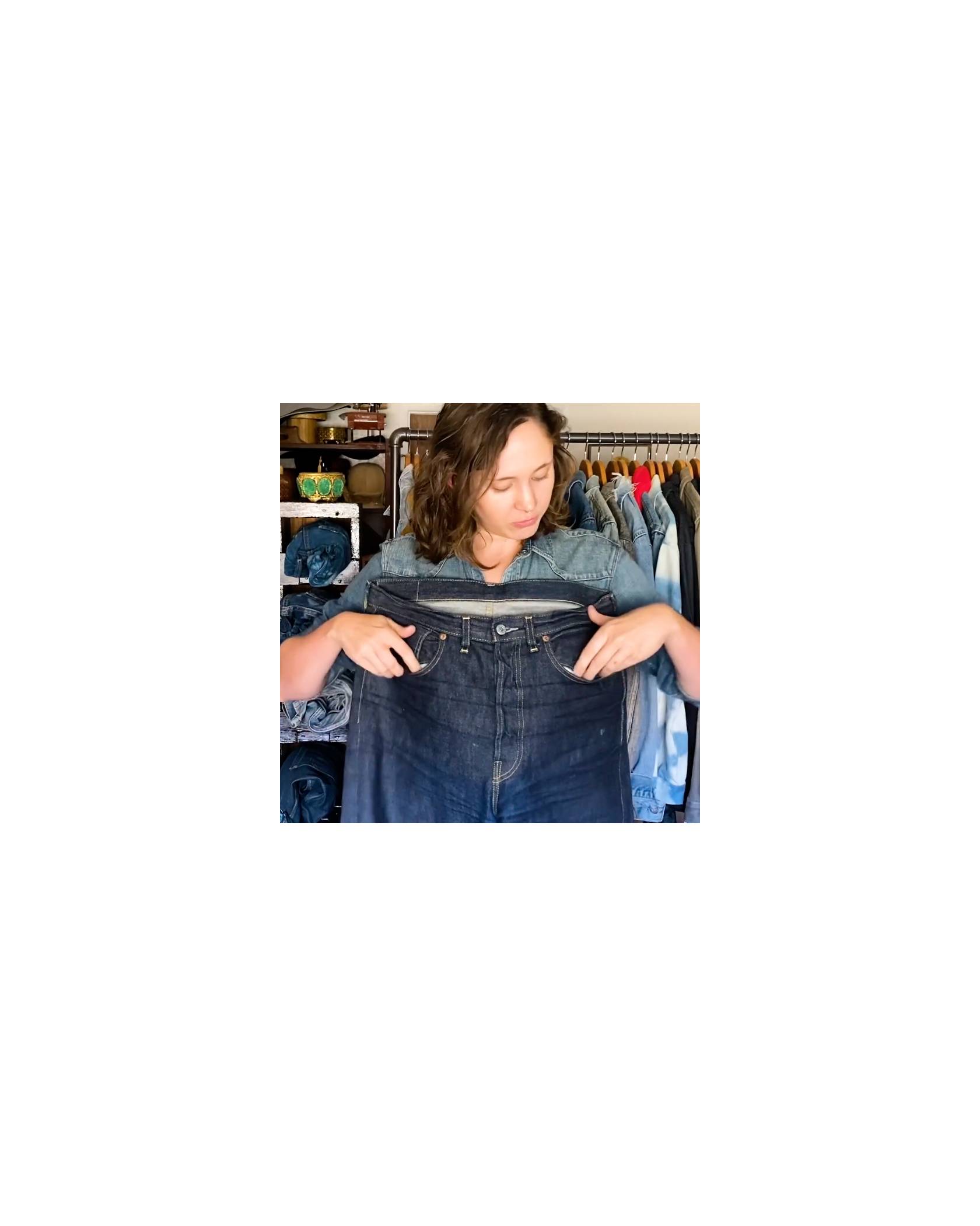 A woman holding jeans showing all the pockets on Levi jeans