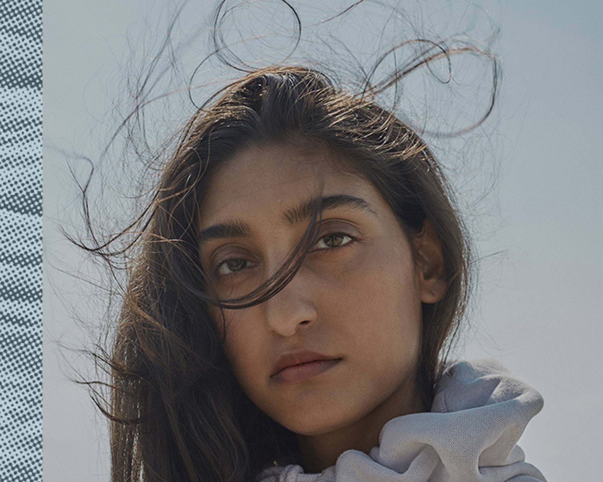 A portrait shot of a woman's face with her hair blowing in the wind