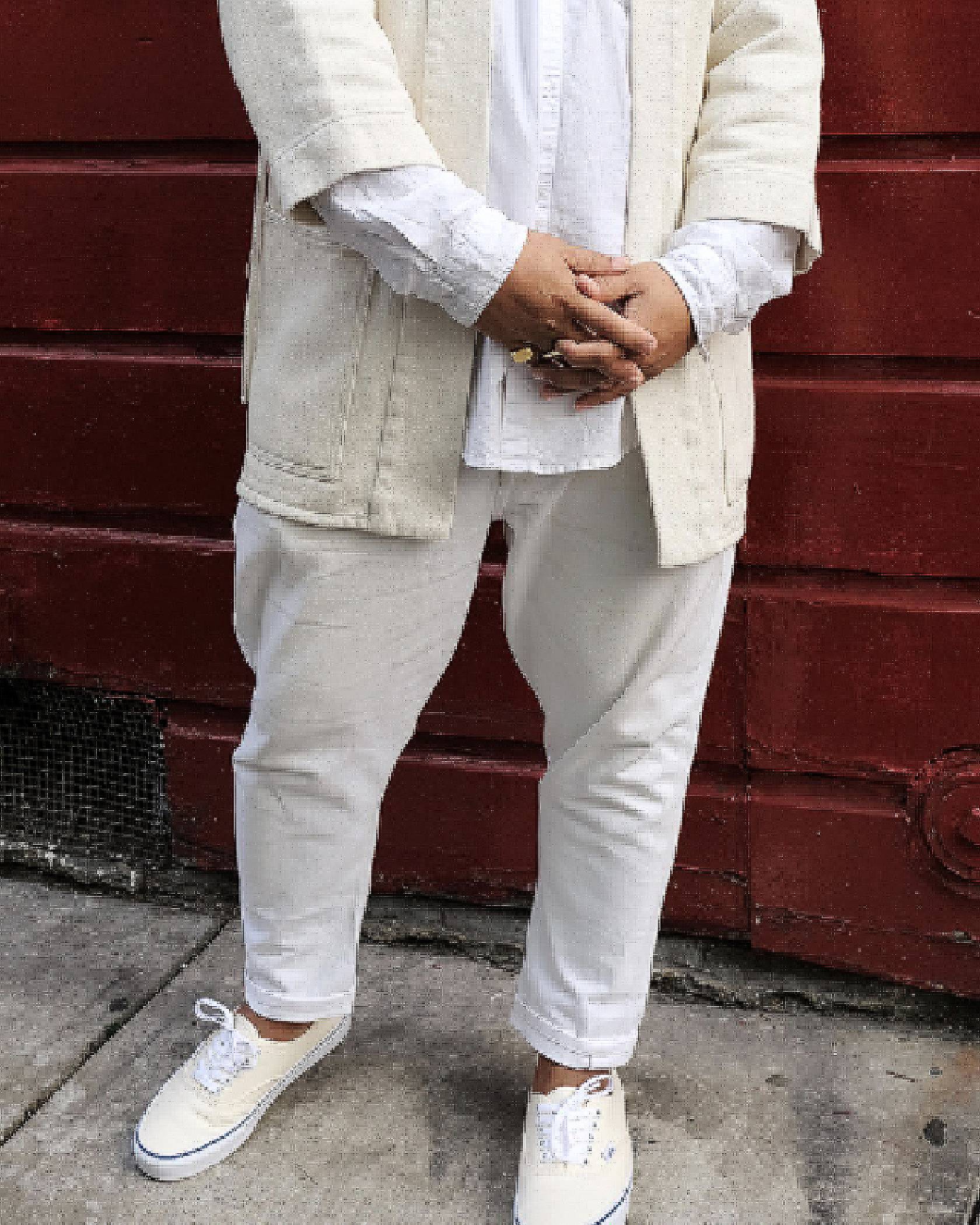 all white outfit in front of brick wall