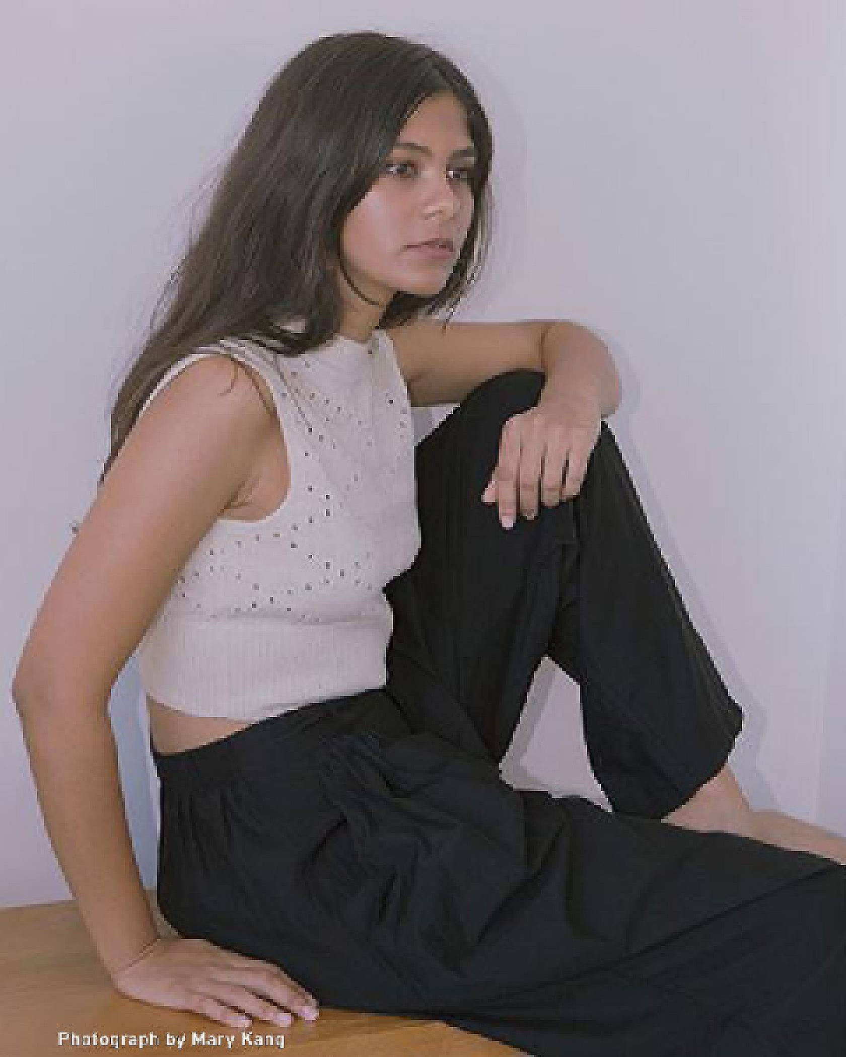 Portrait of Tasnim Ahmed wearing a white eyelet lace top and black pants.