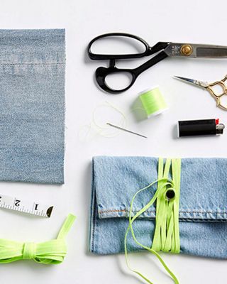 Image of things needed to complete the DIY, including: a pair of old jeans, flat elastic cord, measuring tape, scissors, a button, sewing needle, sewing pins, thread, and lighter.