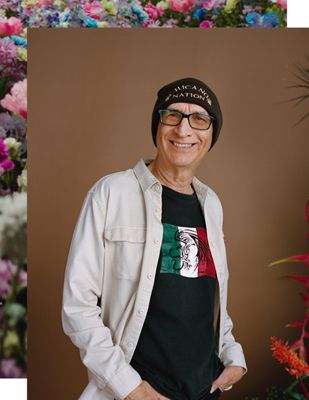 Carlos Montes smiling at the camera wearing a CHICANO NATION beanie.