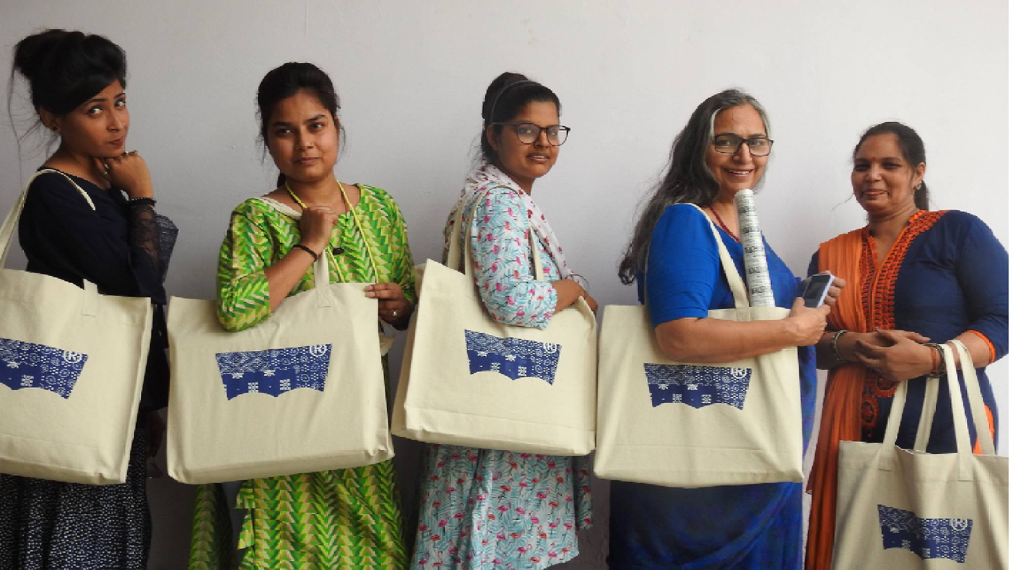 5 women standing with their tote bags