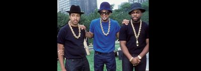 Three men wearing hats, gold chains, and Levi 501 jeans.