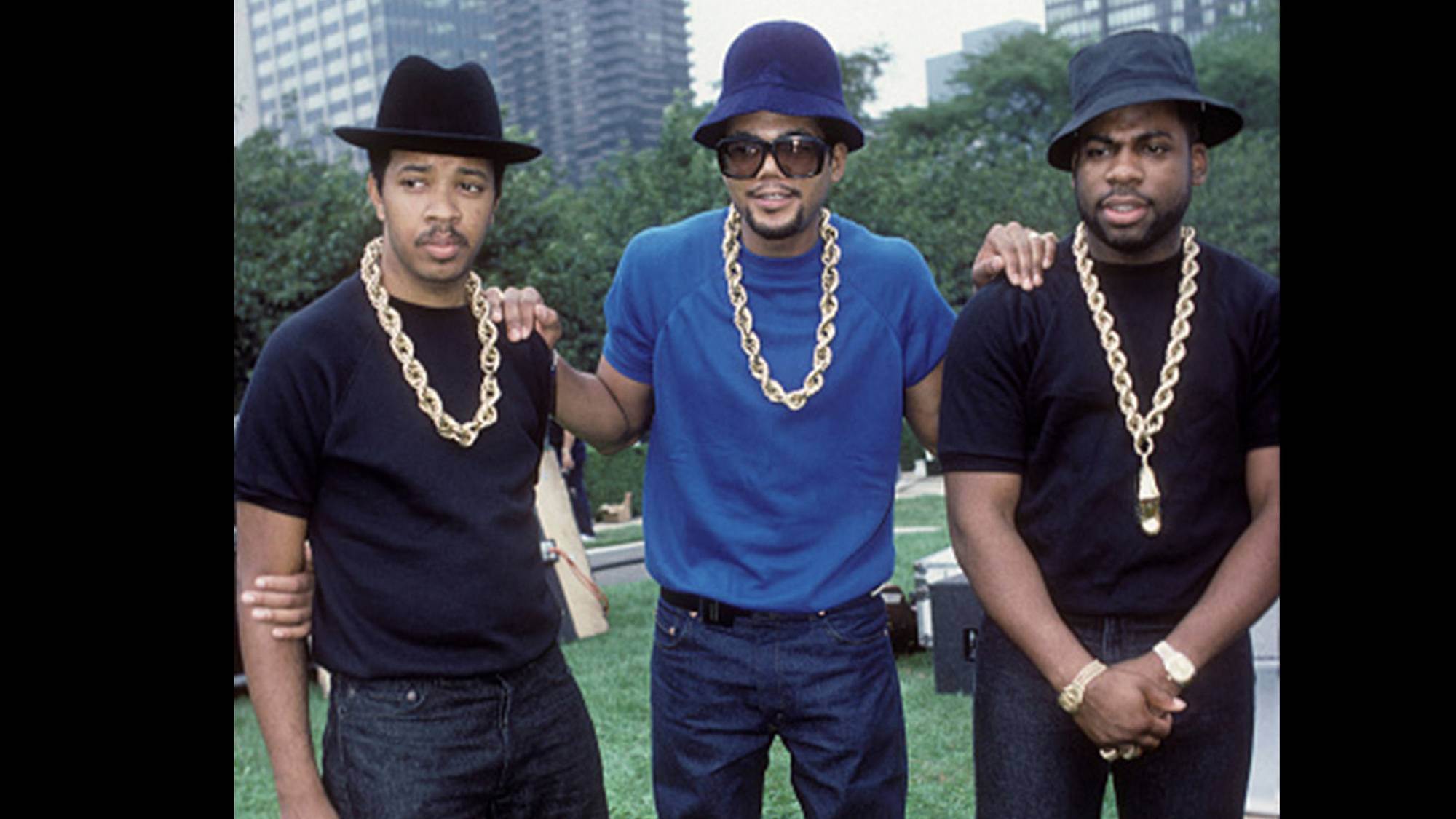 Three men wearing hats, gold chains, and Levi 501 jeans.