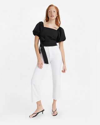 Model wearing black top and white jeans