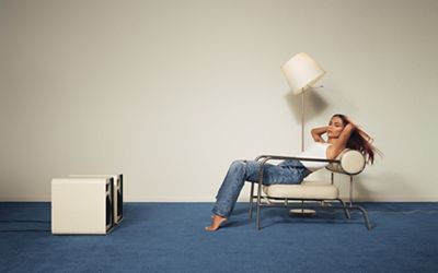 Anitta posing in a chair wearing Levi's 501s 