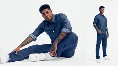 Marcus Rashford wearing dark denim shirt and jeans, and white nikes.