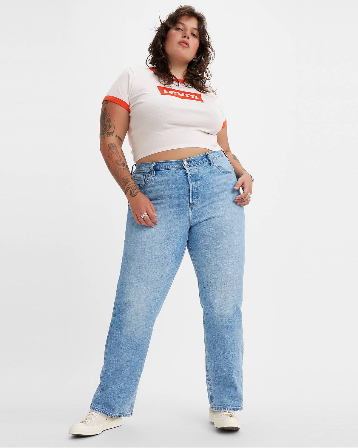 Model wearing light-wash denim jeans and a white Levi's tee with red finishes.